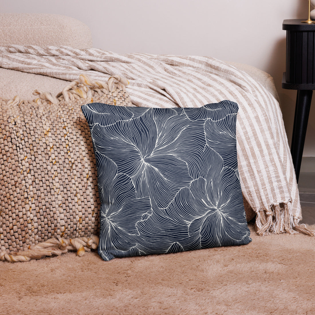 Navy blue floral accent pillow featuring white line designs, adding elegance to a cozy living space.