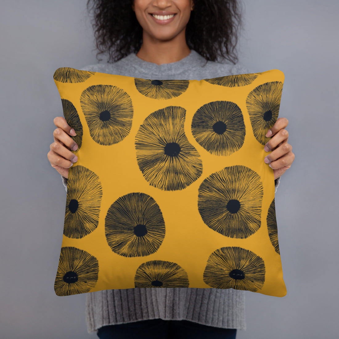 Artisan Floral Print Pillow with yellow background and black floral design in a woman's hands