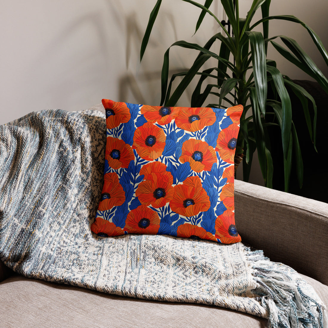 Colorful accent pillow with a vibrant orange and blue poppy floral design on a sofa.