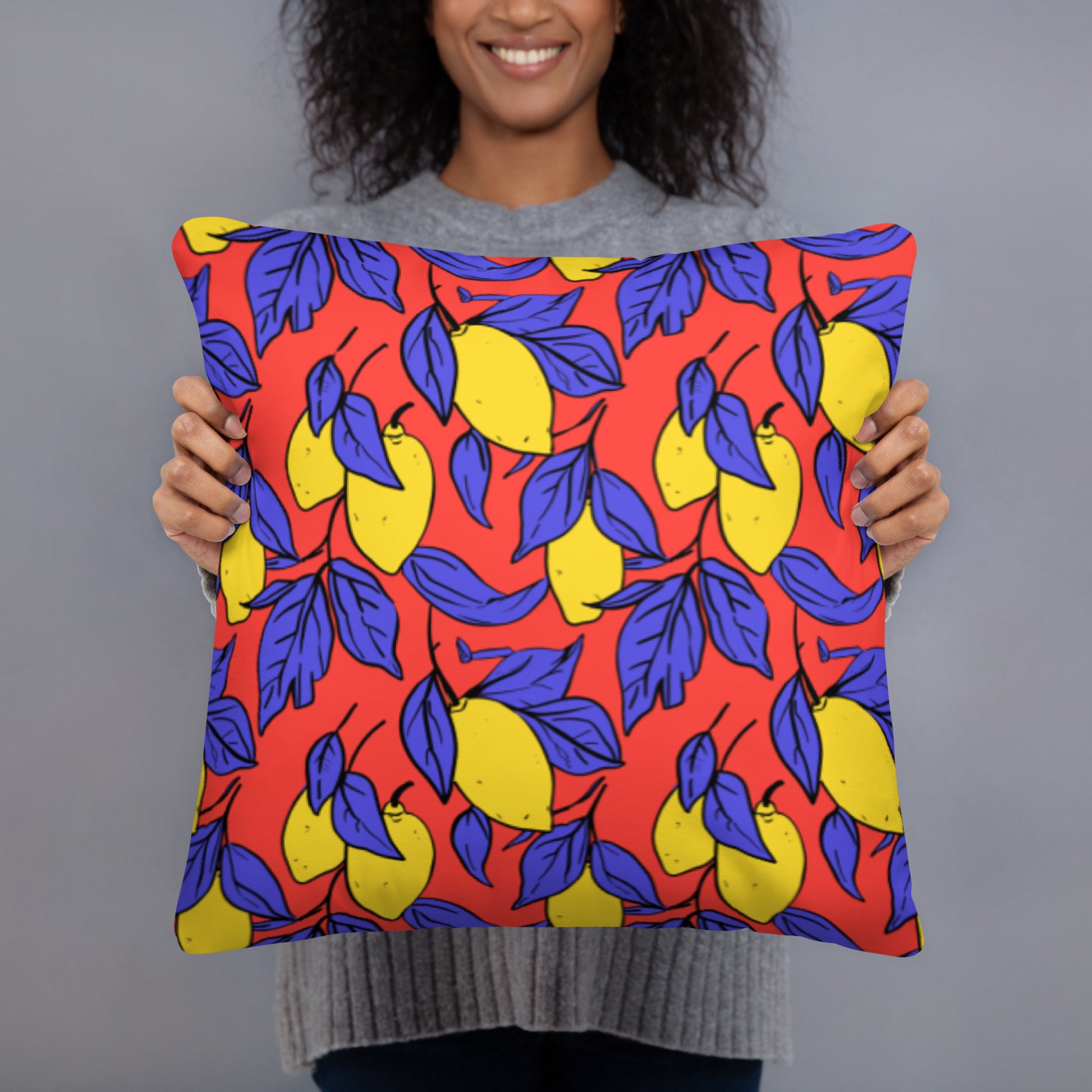 Vibrant accent pillow with a bold lemon and indigo leaf design on a red background.