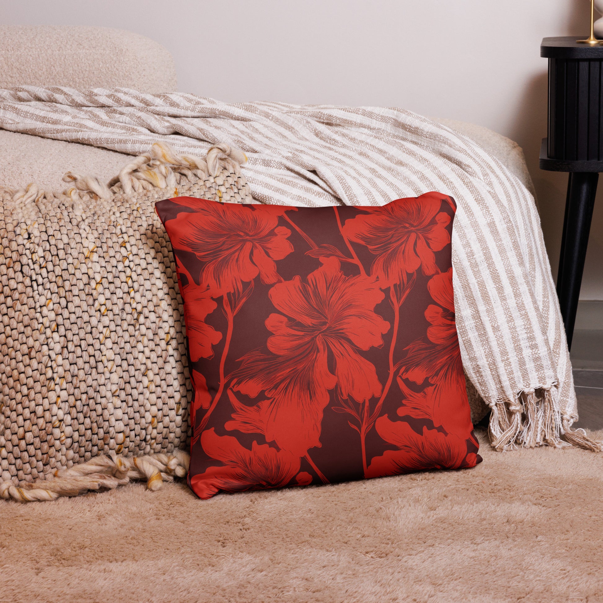 Red Hibiscus Floral Decorative Knitted Pillow on a cozy beige rug and next to patterned textiles.