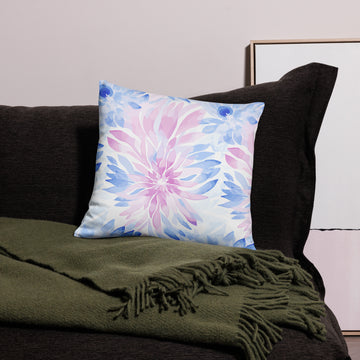 Pillow with pastel floral burst design in pink and blue tones, enhancing a cozy setting.