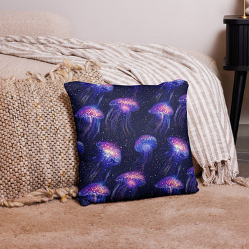 A pillow with vibrant jellyfish designs in purples and blues on a dark background, illustrating a marine-themed, knitted pattern.