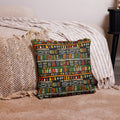 Vibrant ethnic geometric knitted pillow with rich red, green, and yellow patterns placed on a cozy beige sofa.