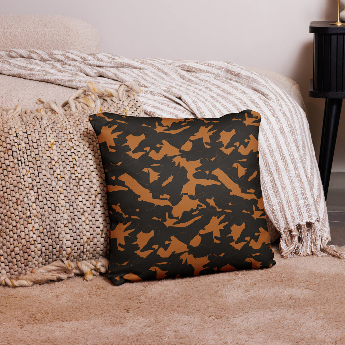 Winter camouflage accent pillow in shades of brown and green, placed on a stylish living room centerpiece with cozy textures.