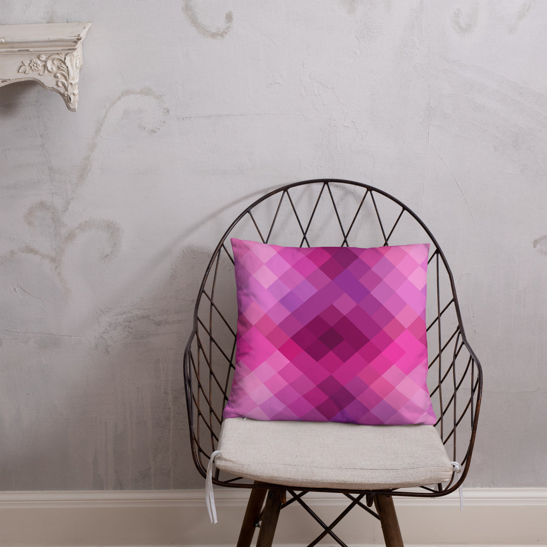 Pink and purple geometric patterned pillow on cozy dark fabric background, perfect for winter decor.