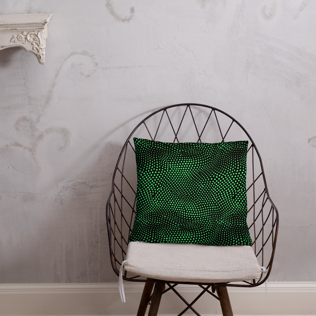 Emerald green pillow with a unique geometric knit pattern, placed on a dark blue textured fabric.