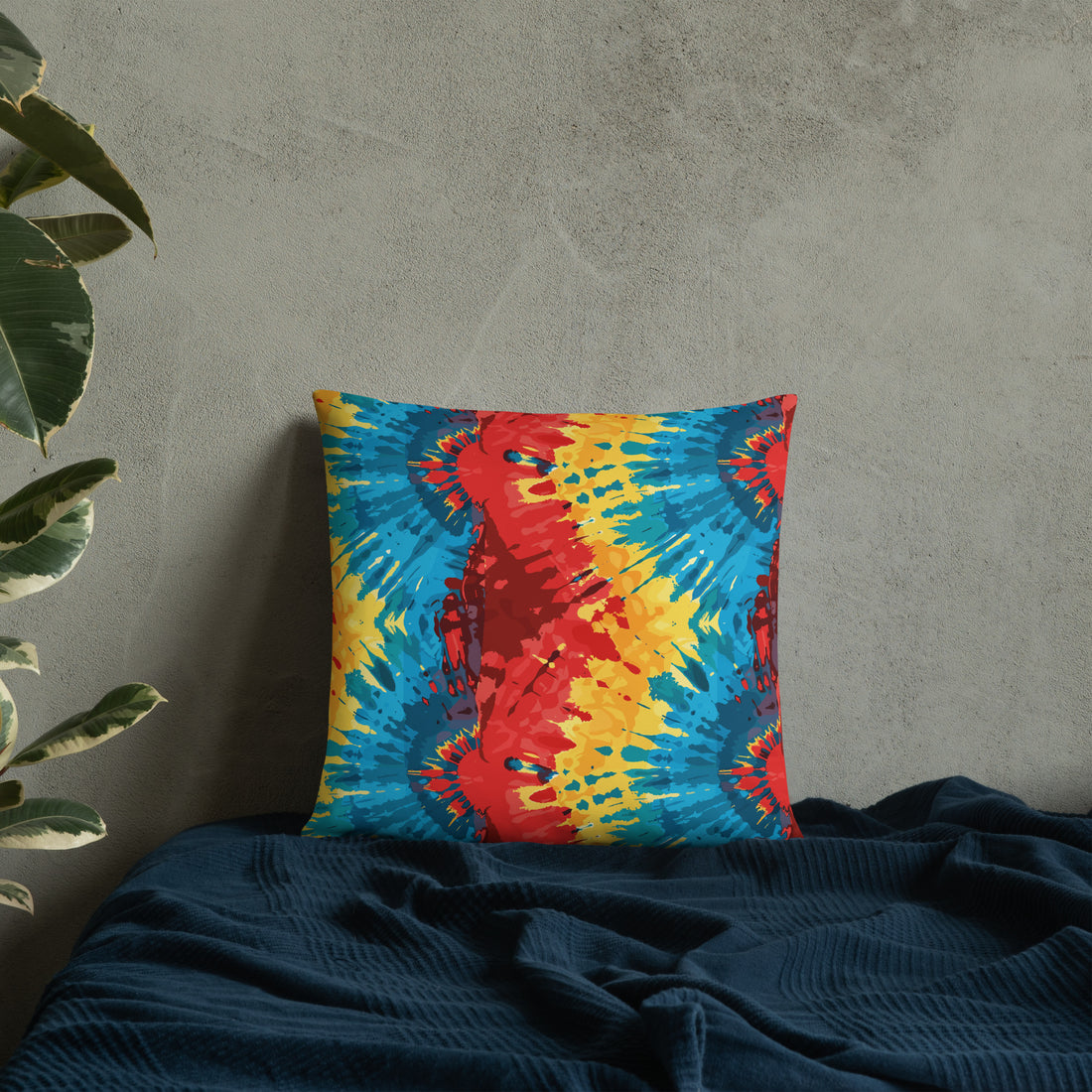 Bright parrot kaleidoscope pillow with bold red, blue, and yellow patterns against a textured wall.