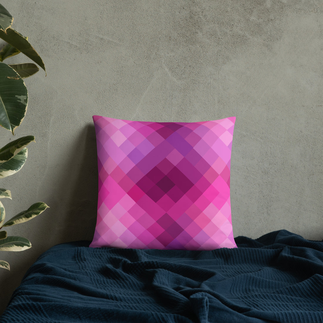 Pink and purple geometric patterned pillow on cozy dark fabric background, perfect for winter decor.