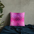 Pink and purple geometric patterned pillow on cozy dark fabric background, perfect for winter decor.