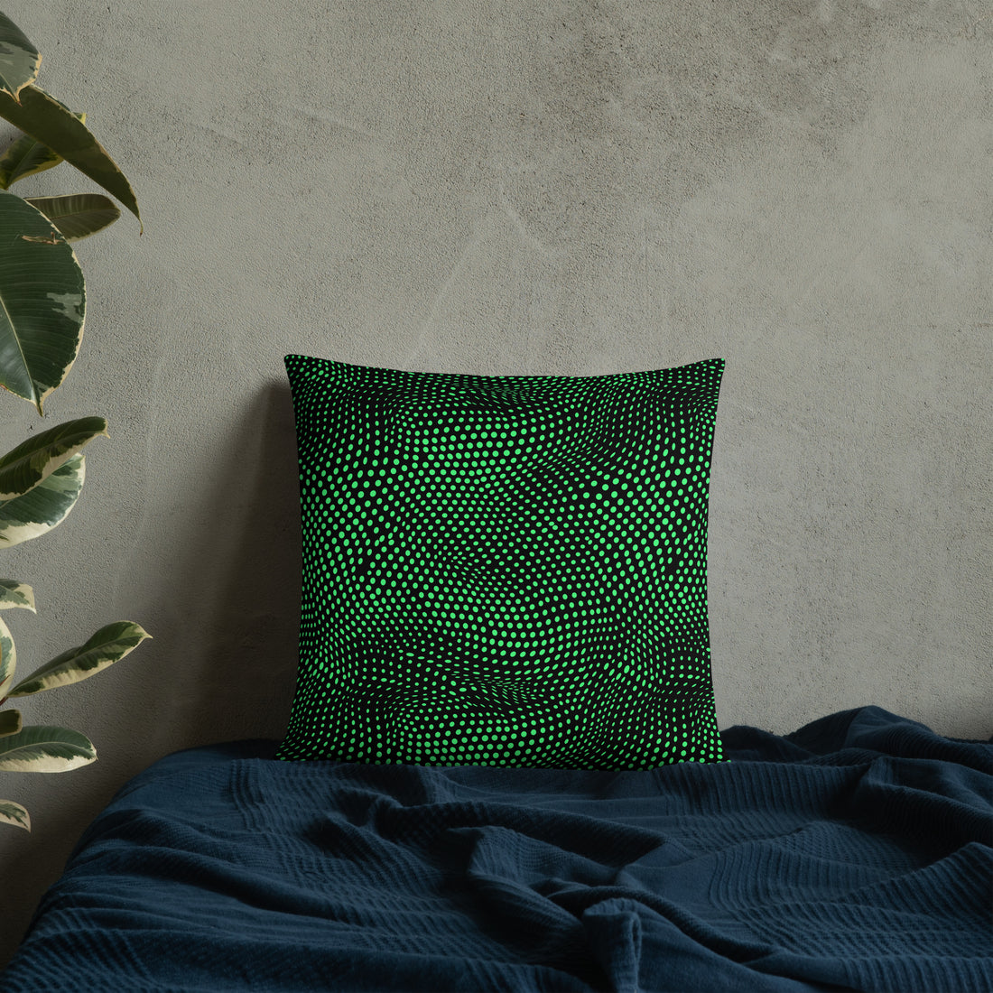 Emerald green pillow with a unique geometric knit pattern, placed on a dark blue textured fabric.