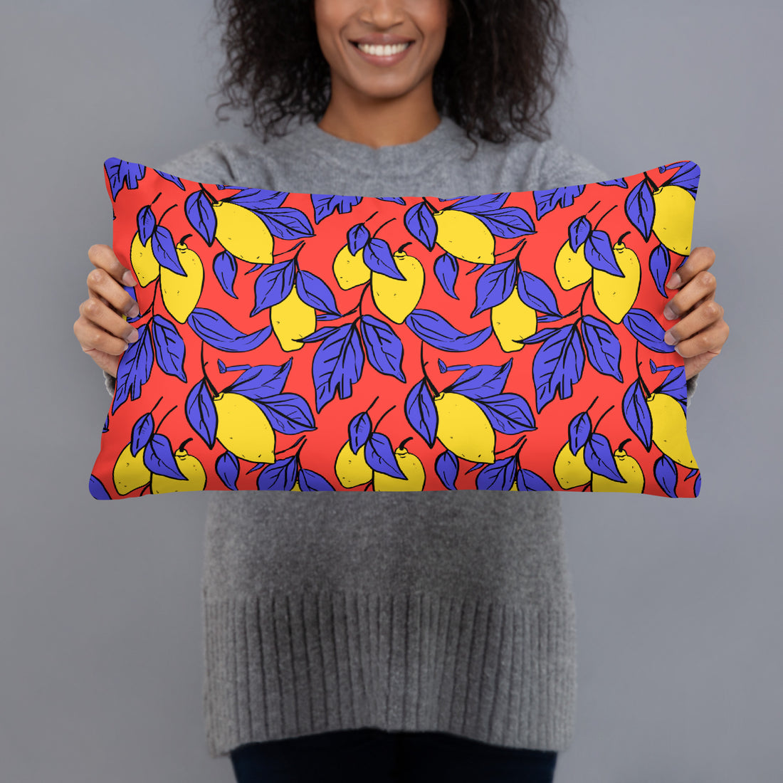 Vibrant accent pillow with a bold lemon and indigo leaf design on a red background.