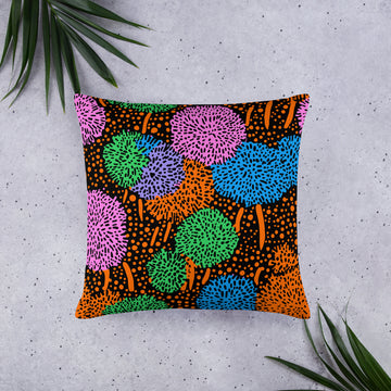 Vibrant geometric print throw pillow featuring multicolored pom-pom designs on a black background.