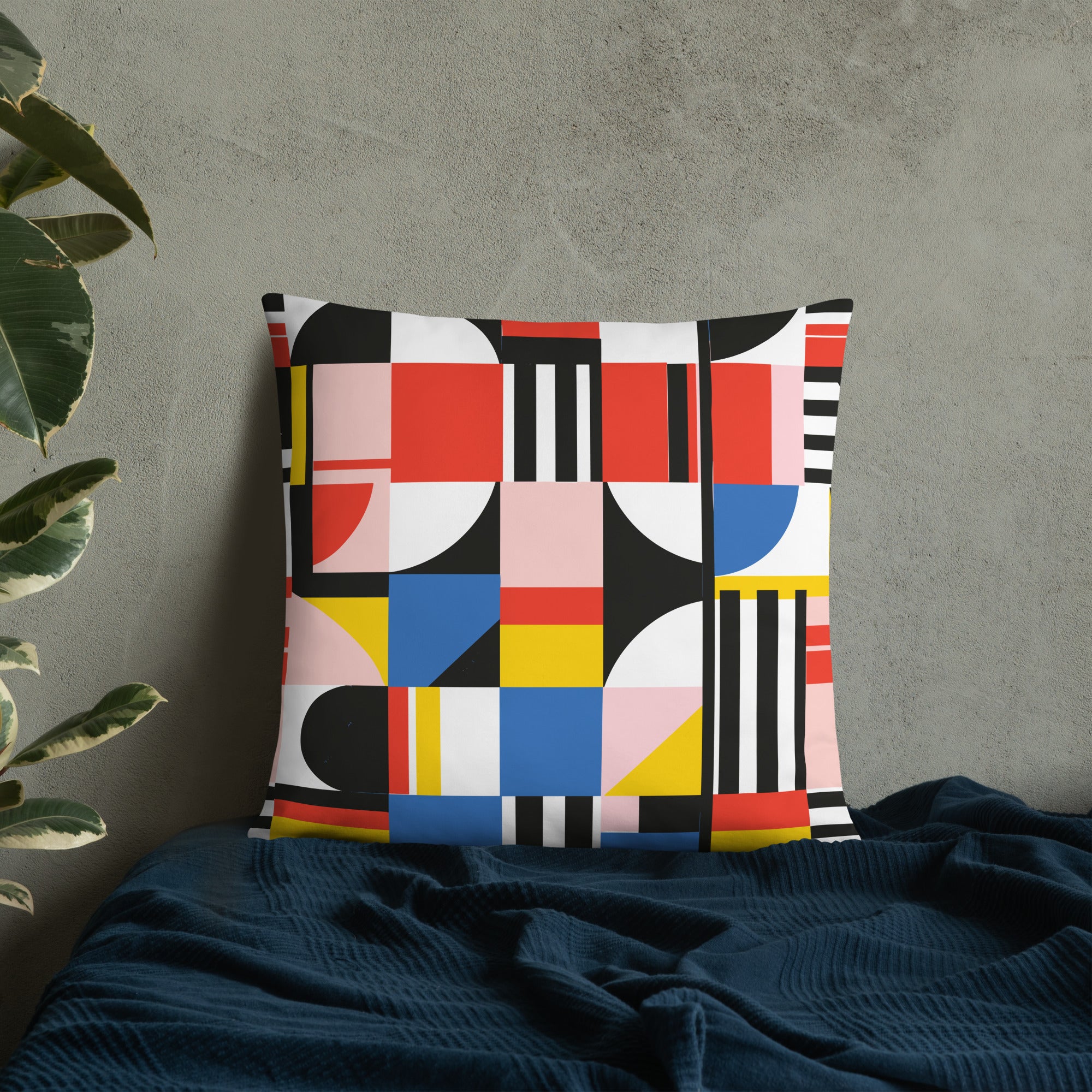 Vibrant geometric accent pillow with red, blue, yellow, and black patterns on a textured grey background.