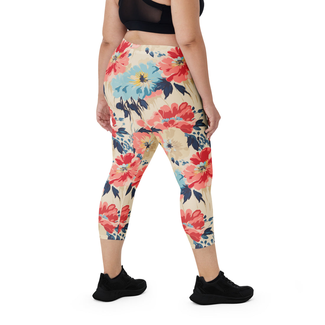 Woman wearing vibrant capri leggings with a large poppy floral design, set against a track field.