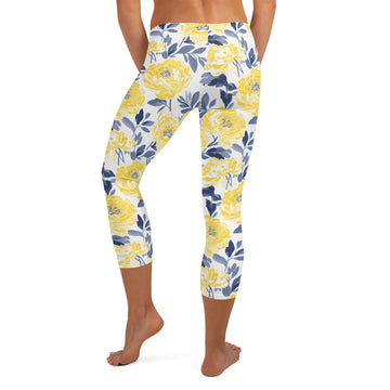 Yellow peony floral capri leggings with deep blue foliage on a white background, perfect for winter fashion.