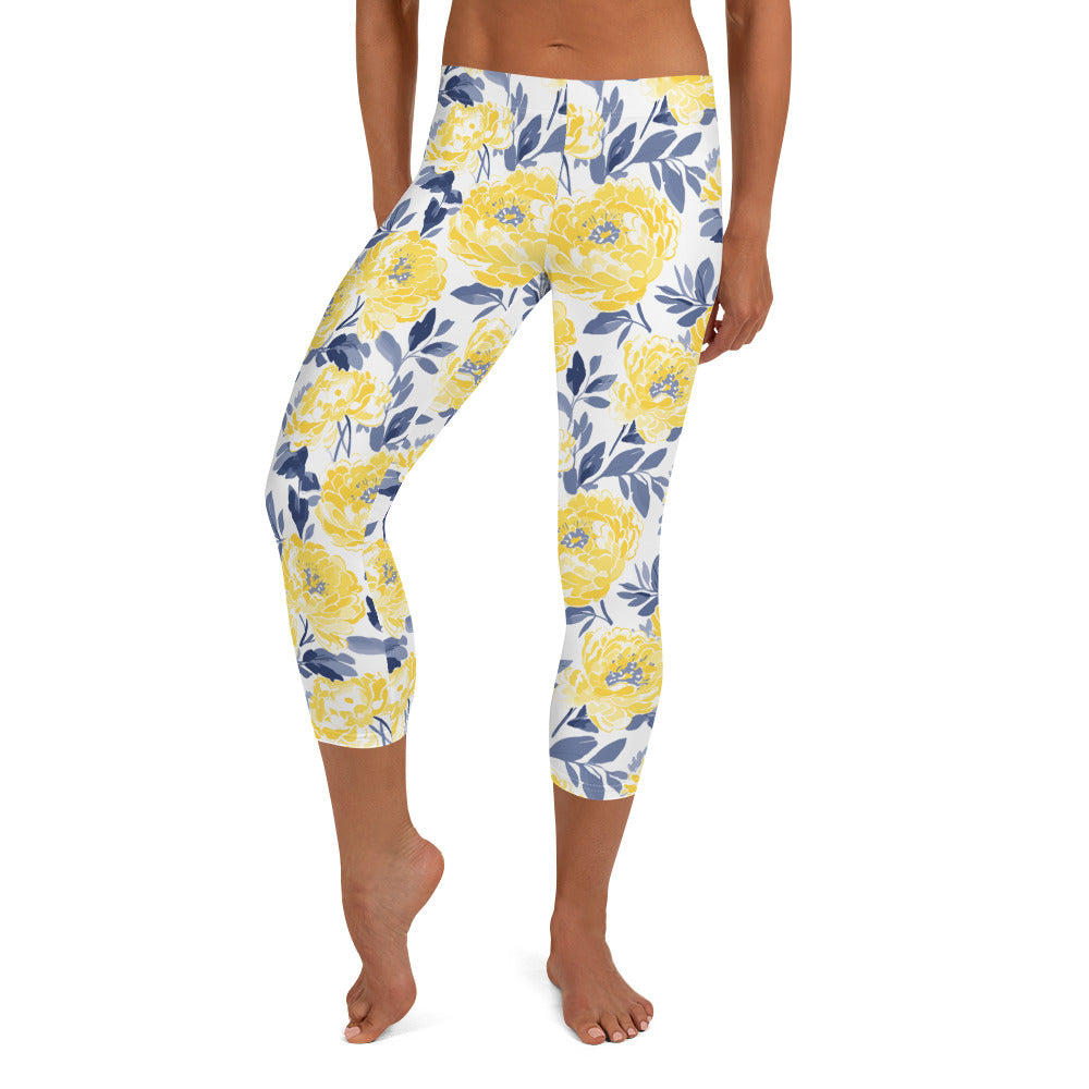 Yellow peony floral capri leggings with deep blue foliage on a white background, perfect for winter fashion.