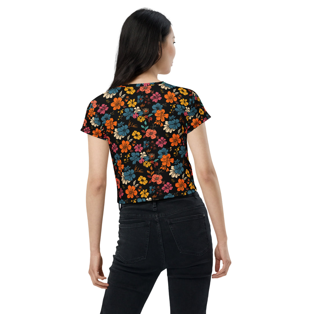 Woman wearing a vibrant floral black crop tee with red, blue, and orange blooms, suitable for stylish winter fashion.