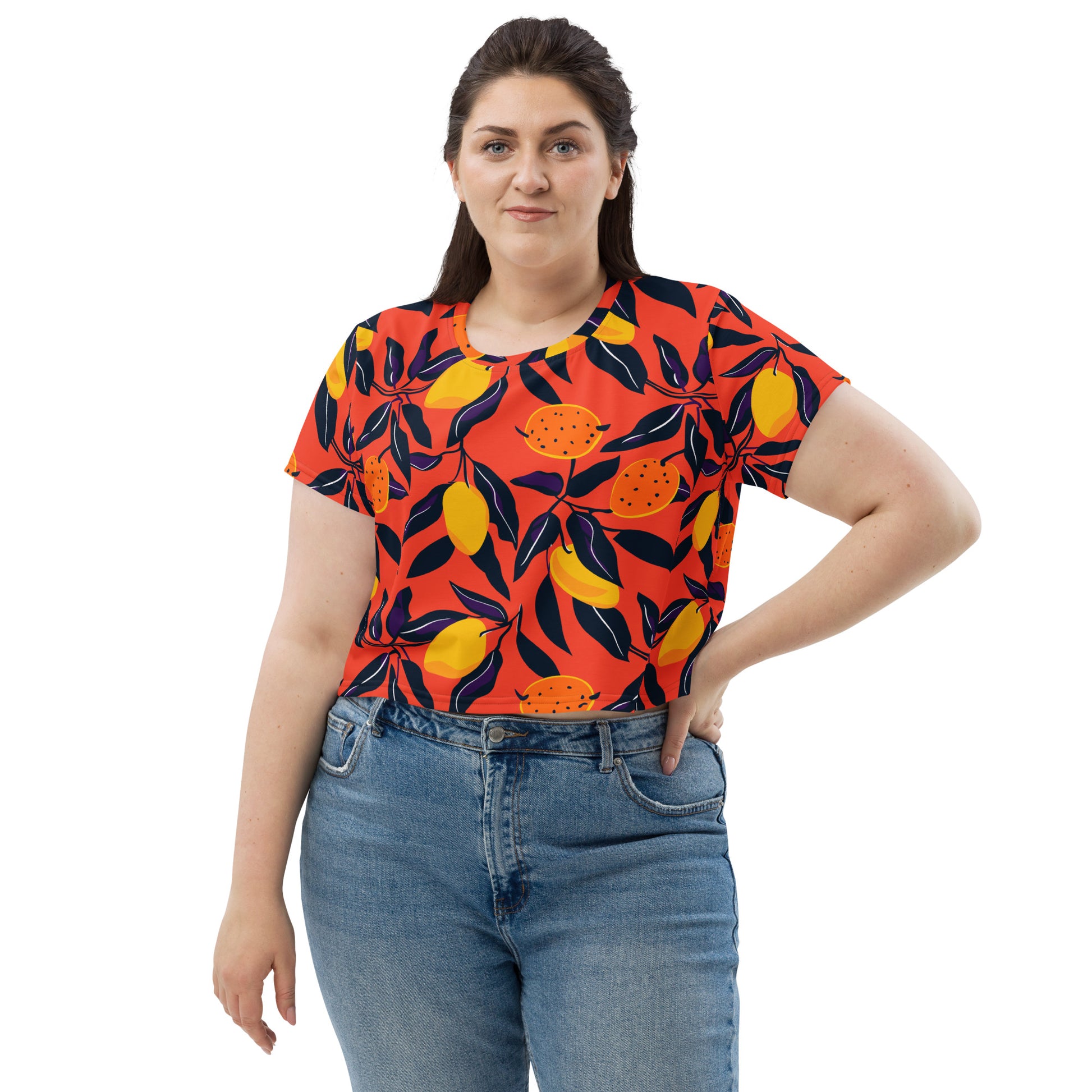 Vibrant crop tee featuring citrus fruit design against a bright red background, model wearing denim jeans.