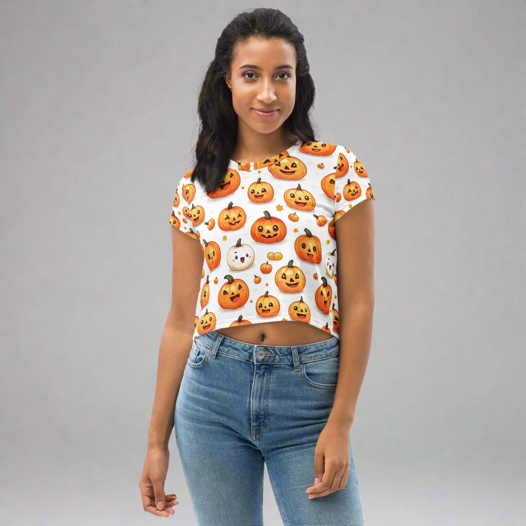 A cropped tee with an all-over print of playful pumpkins and ghosts, designed for women, featuring vibrant colors.