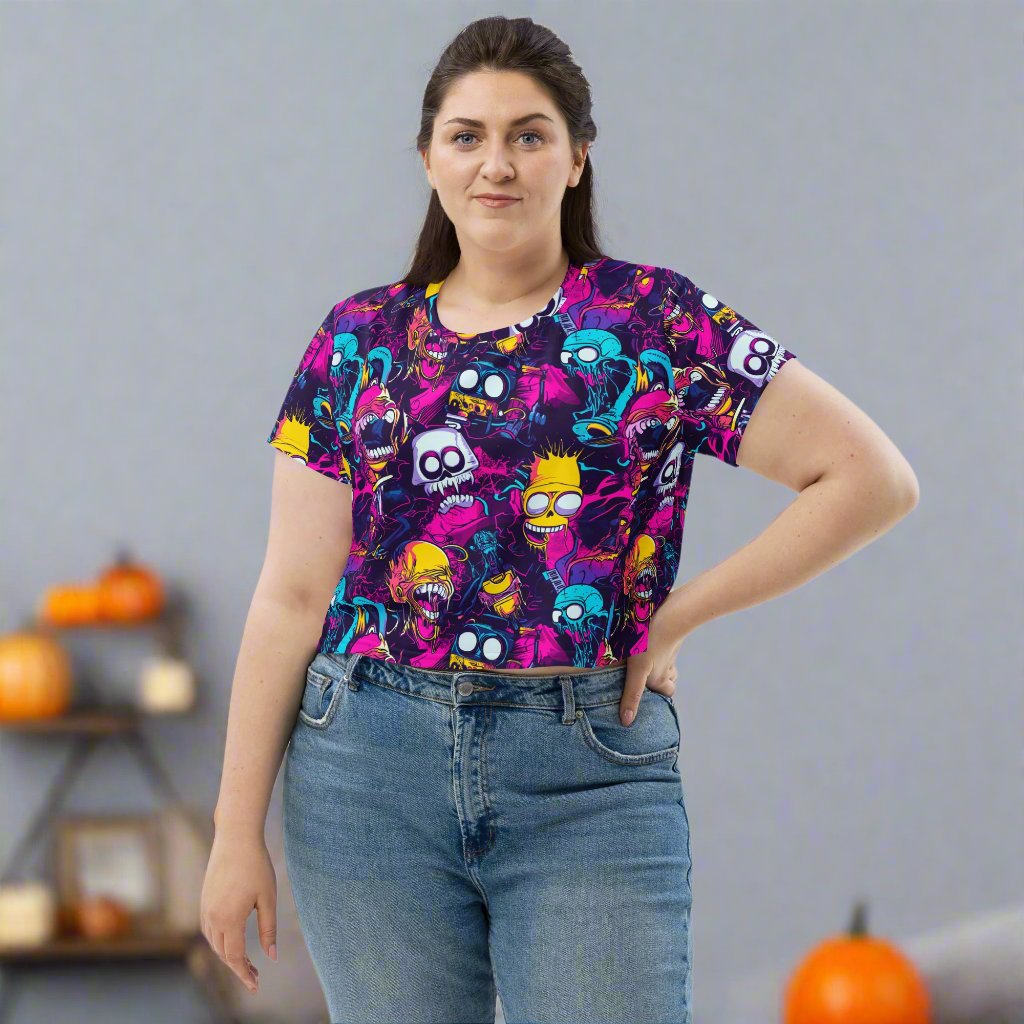 Halloween-themed crop tee featuring colorful ghost graphics on a black background, women modeling in casual outfit.