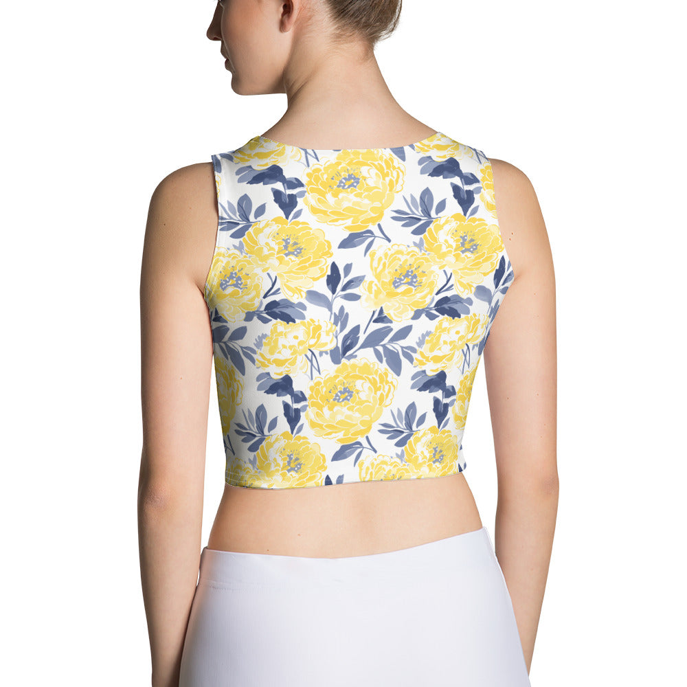 Woman wearing a crop top with vibrant yellow peony floral design on a white background.