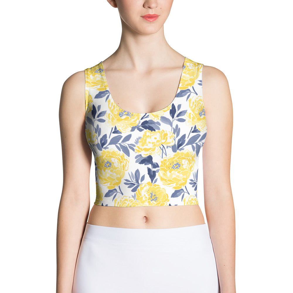 Woman wearing a crop top with vibrant yellow peony floral design on a white background.