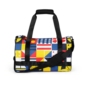 Vibrant geometric print gym bag featuring colorful patterns in blue, red, yellow, and black with padded handles.