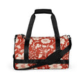 Floral print gym bag in red with cream floral design, featuring padded handles and adjustable strap.