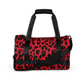 Bold leopard print gym bag in red and black, featuring dual padded handles and a crossbody strap.