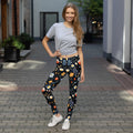 Eco-friendly leggings showcasing vibrant red, white, and orange flowers on a black background. Ideal for winter fashion.