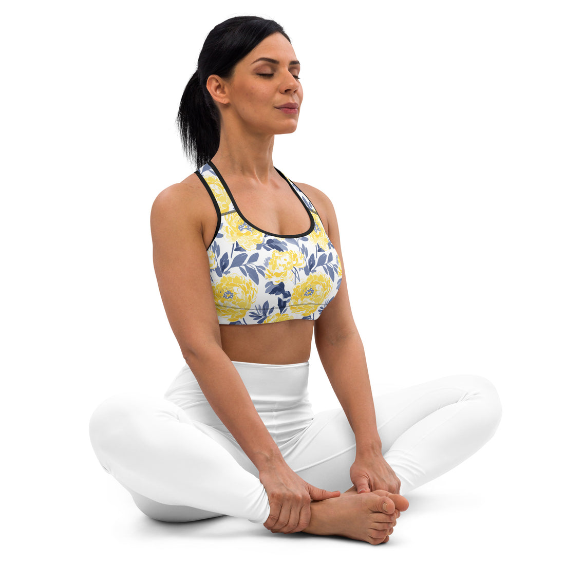 Woman wearing a padded sports bra with vibrant yellow and blue floral pattern, demonstrating a yoga pose.