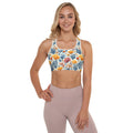 Woman wearing a padded sports bra with a vibrant coral reef design featuring orange and blue sea motifs.