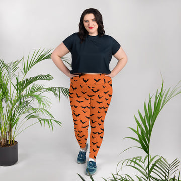 Halloween Bat Print Plus Size Leggings in orange with black bats worn by a woman in a stylish top.