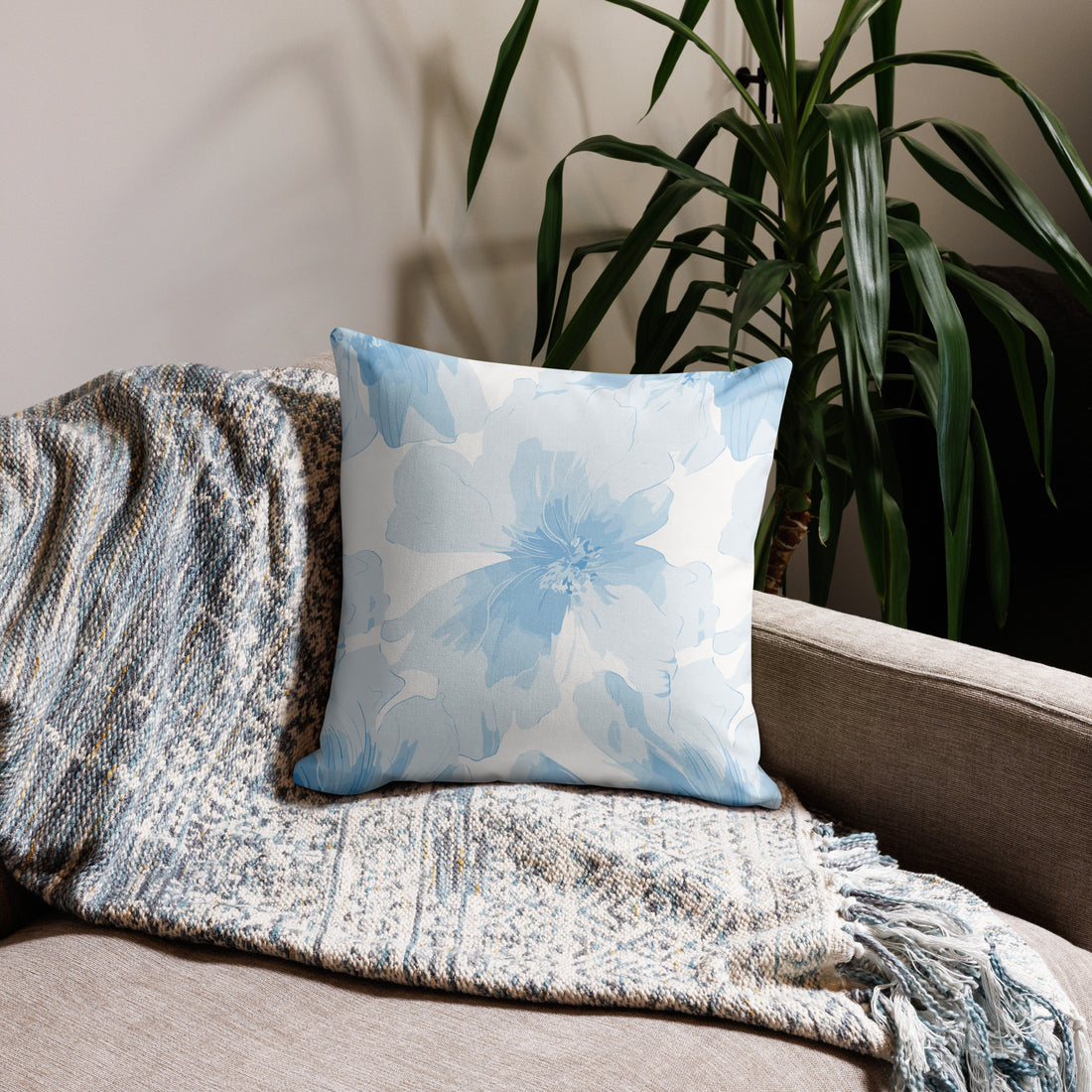 Blue floral knit pillow on a couch, featuring a calming light blue pattern, perfect for winter home decor.