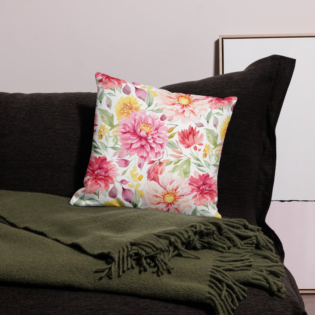 Colorful pillow with pink, yellow, and green floral design on a dark sofa, perfect for winter decor