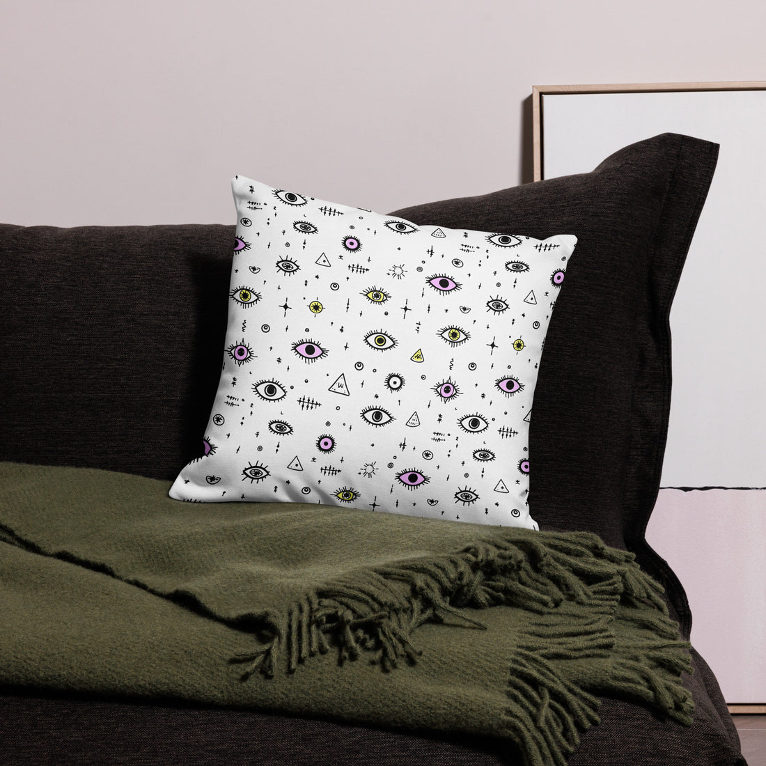 Mystic Eye Pattern Pillow with purple and yellow accents on a white background, on a dark couch with a green blanket, showcasing unique winter decor style.