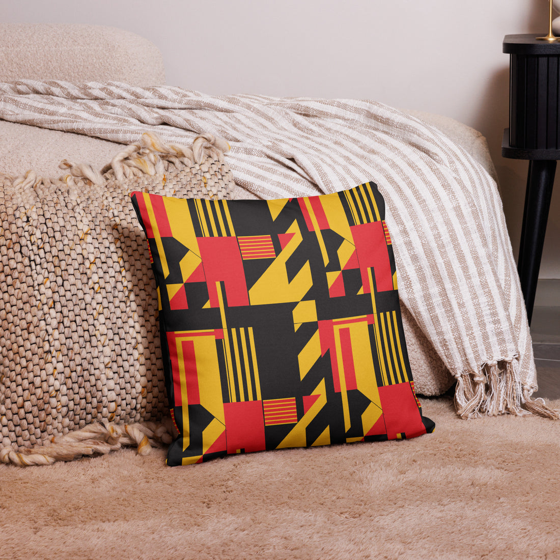 Colorful knitted pillow with a vibrant geometric design in black, red, and yellow.