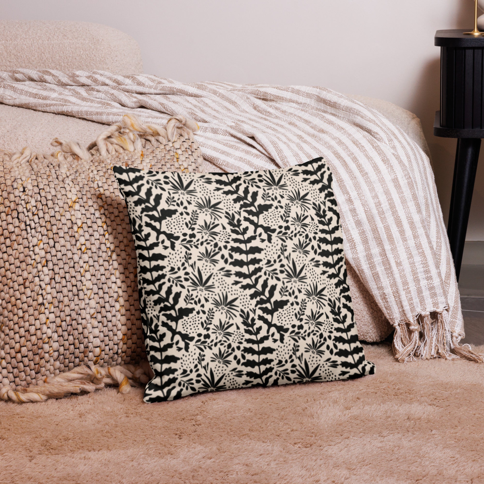 Black and beige pillow with a sophisticated botanical design, featuring intricate plant patterns that add a touch of elegance to any living space.