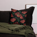 Pillow with poppy floral knit design in red and green on black, cozy winter decor.