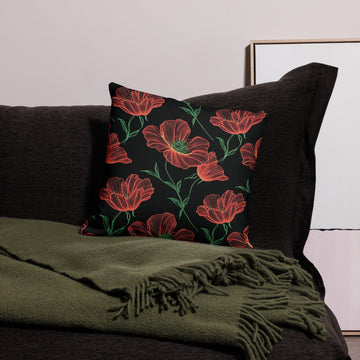 Pillow with poppy floral knit design in red and green on black, cozy winter decor.