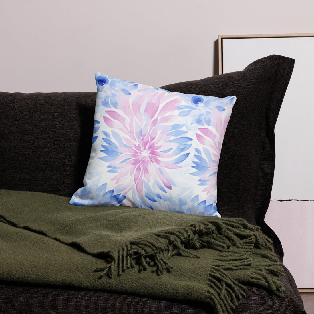 Knitted pillow with pastel floral design featuring pink and blue colors on a sofa, creating a cozy winter ambiance.