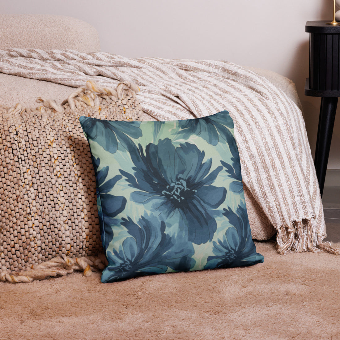 Decorative pillow with teal floral design, knitted texture, lying on cozy living room setting.