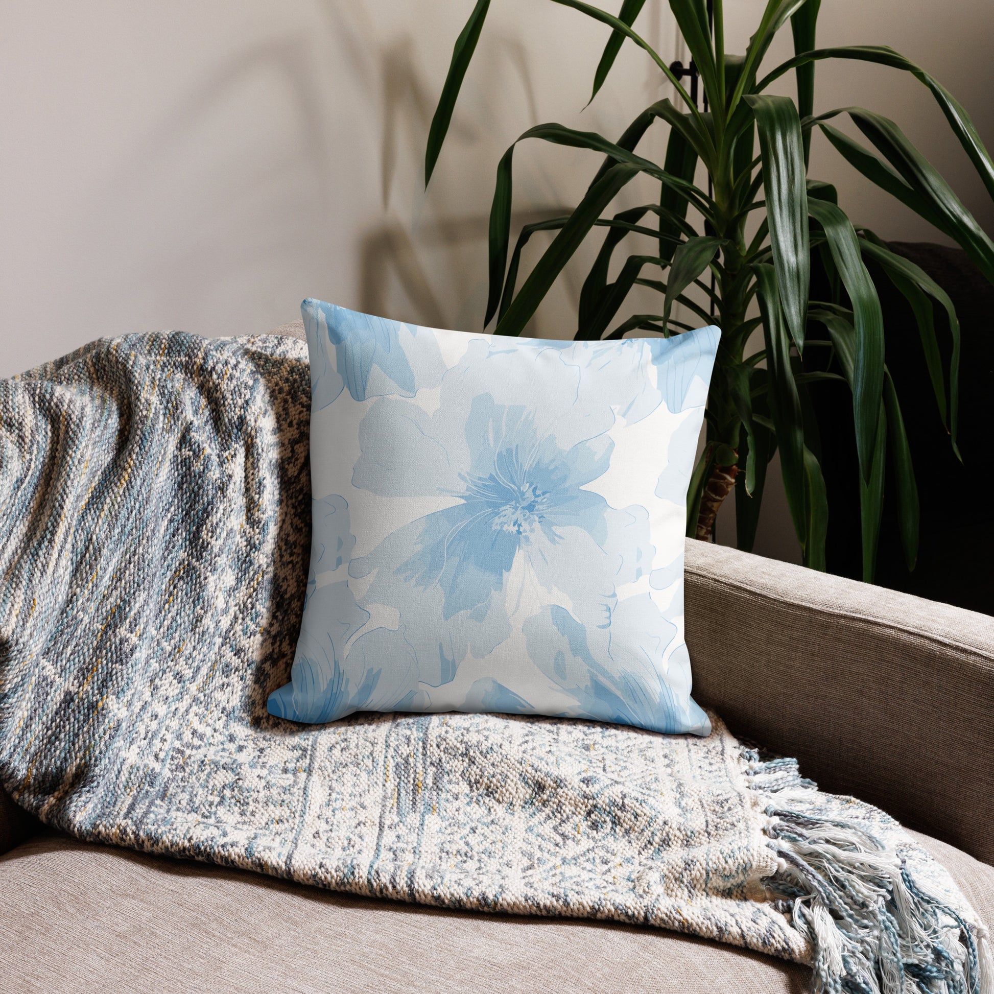 Blue floral knit pillow on a couch, featuring a calming light blue pattern, perfect for winter home decor.