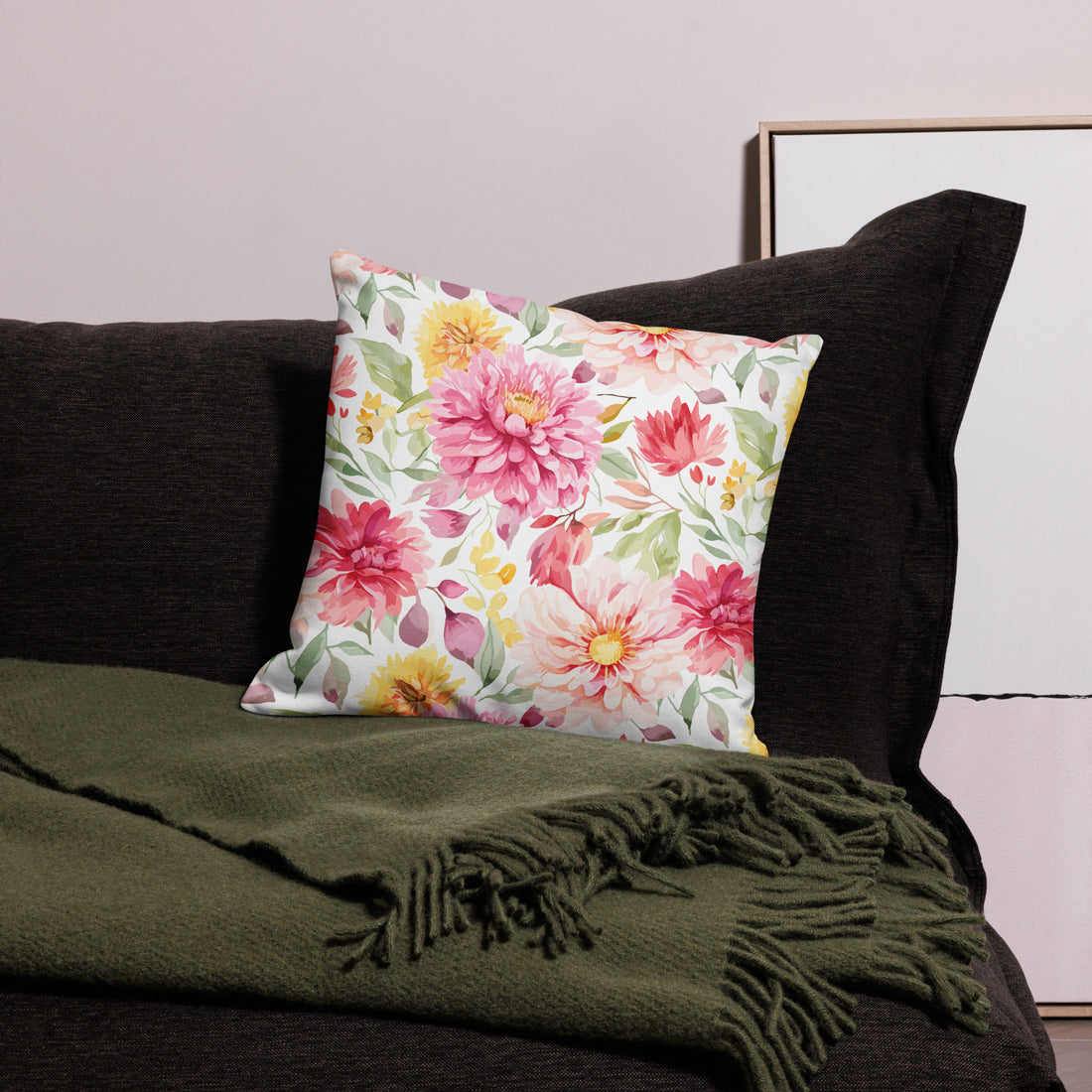 Colorful pillow with pink, yellow, and green floral design on a dark sofa, perfect for winter decor