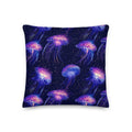 Knitted pillow featuring vibrant jellyfish design in iridescent purple and pink on a midnight blue background.