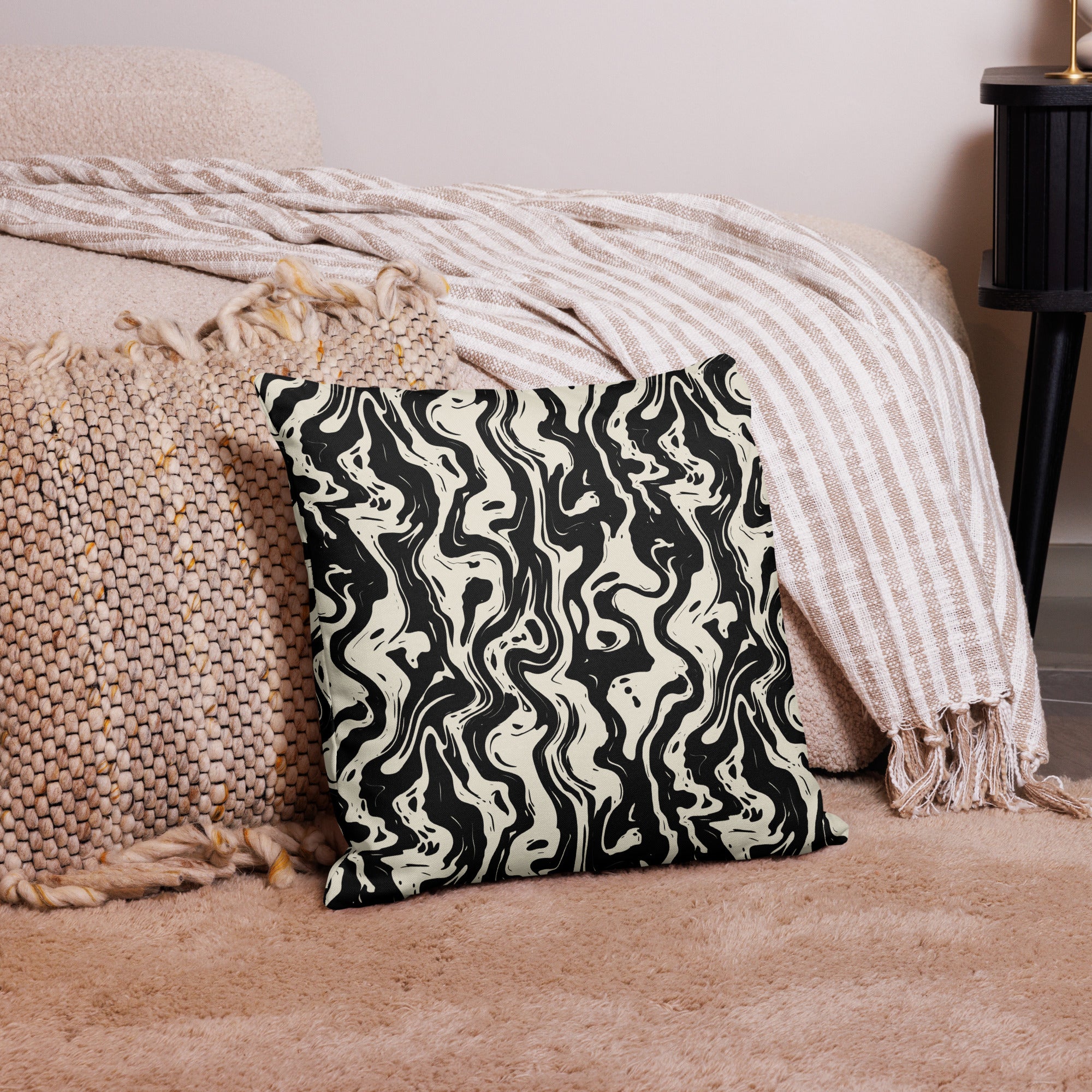 Black and cream marbled pattern pillow on a cozy beige setting, featuring luxurious knit design showcasing elegant swirls, perfect for winter decor.