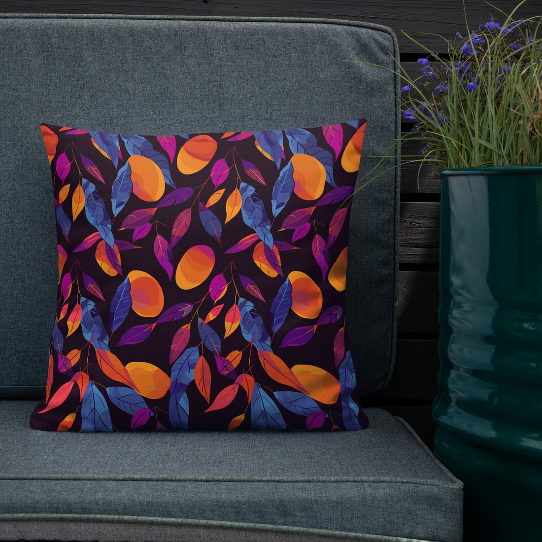 Pillow with a vibrant autumn leaf pattern featuring orange, blue, and magenta hues on a dark background.