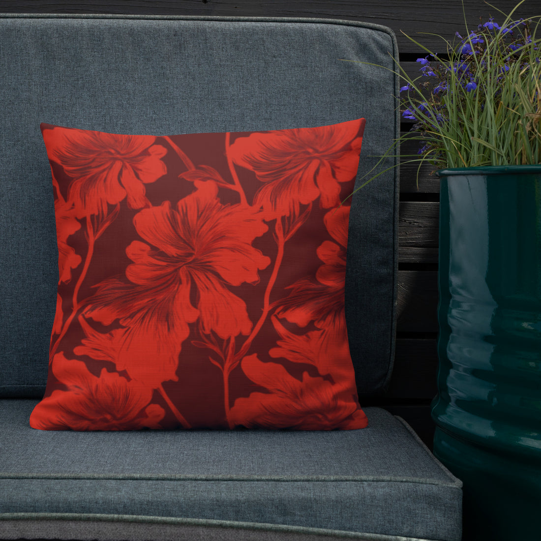 Red pillow with vibrant hibiscus floral pattern on a maroon background