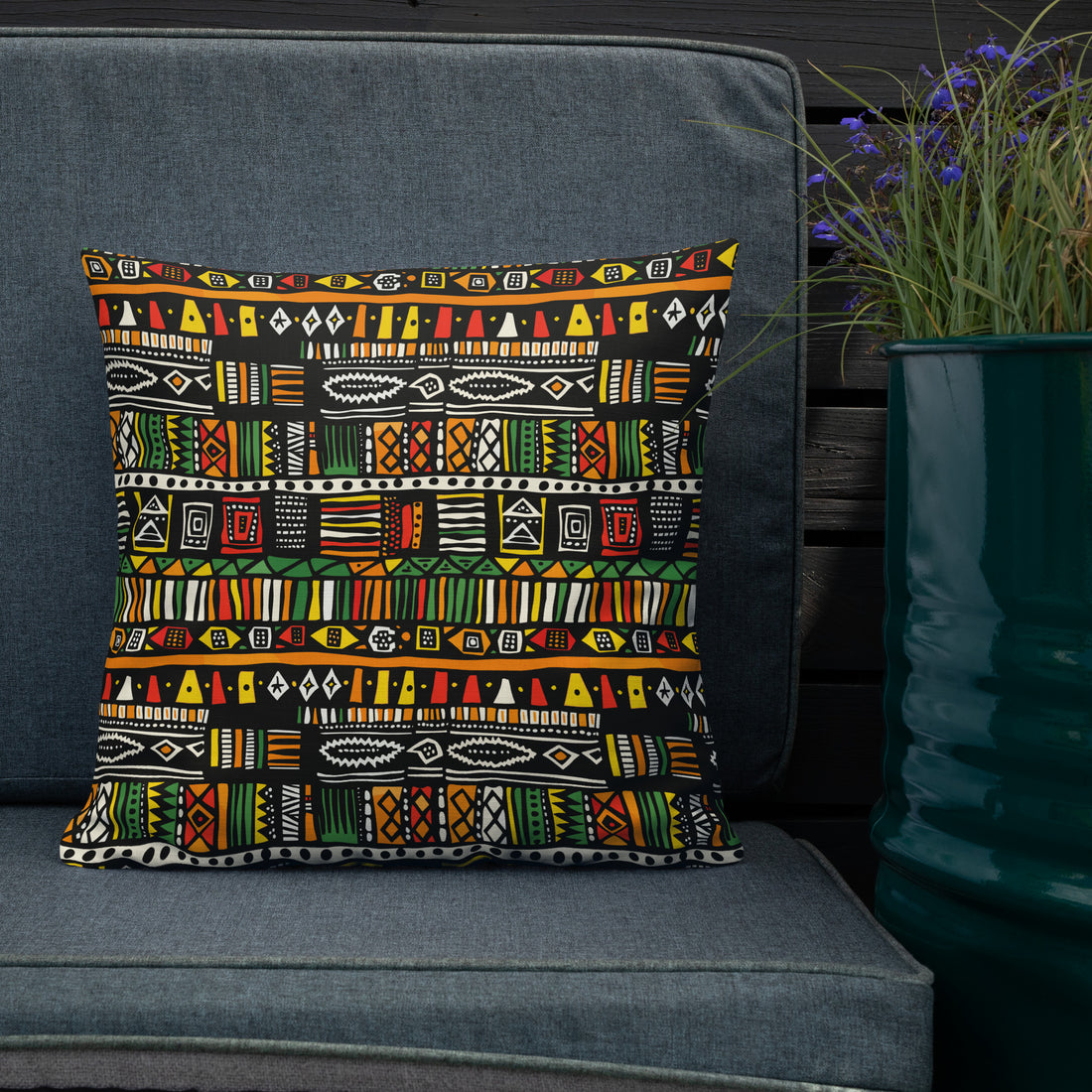 Pillow with vibrant tribal pattern in red, orange, green, and yellow, perfect for holiday decor.